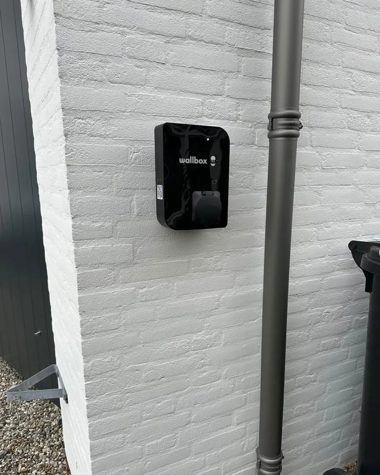 Wallbox gemonteerd op een witte muur, strak uitgelijnd